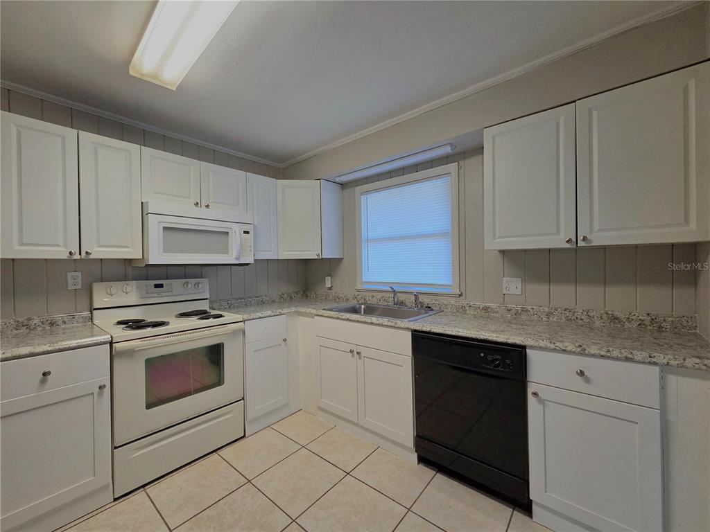 3221 Crutchfield Road Lakeland, FL 33805 - Photo 35 of 49 a kitchen with granite countertop white cabinets and white appliances