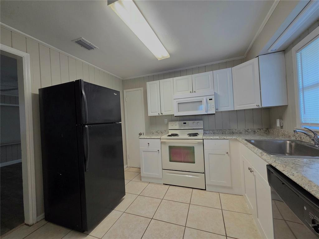 3221 Crutchfield Road Lakeland, FL 33805 - Photo 36 of 49 a kitchen with white cabinets and refrigerator