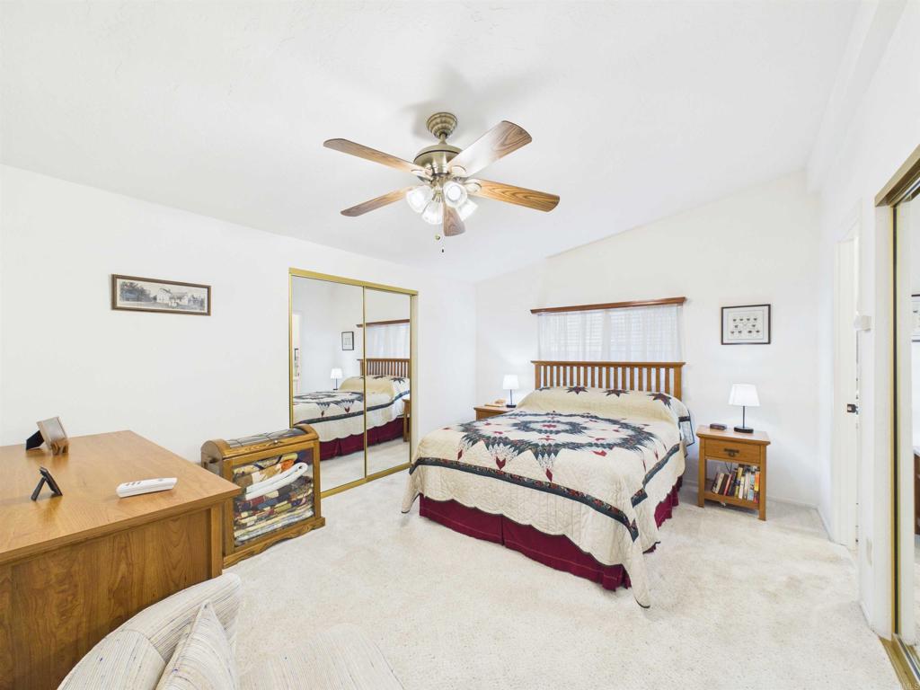 18218 Paradise Mountain Road, Unit 220 Valley Center, CA 92082 - Photo 31 of 48 a bedroom with a bed and a chandelier