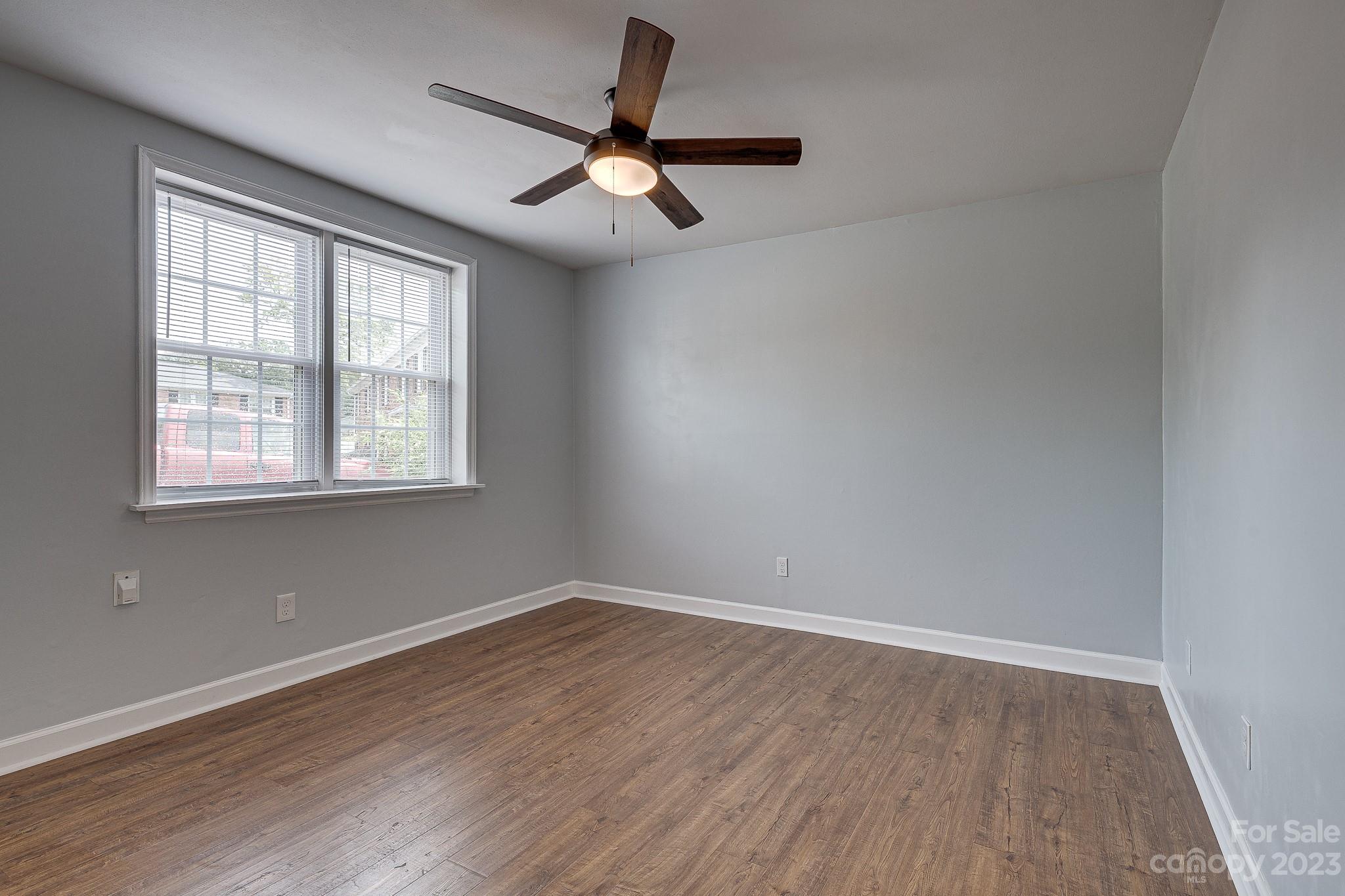 910 McAlway Road, Unit B Charlotte, NC 28211 - Photo 18 of 37 an empty room with wooden floor fan and windows
