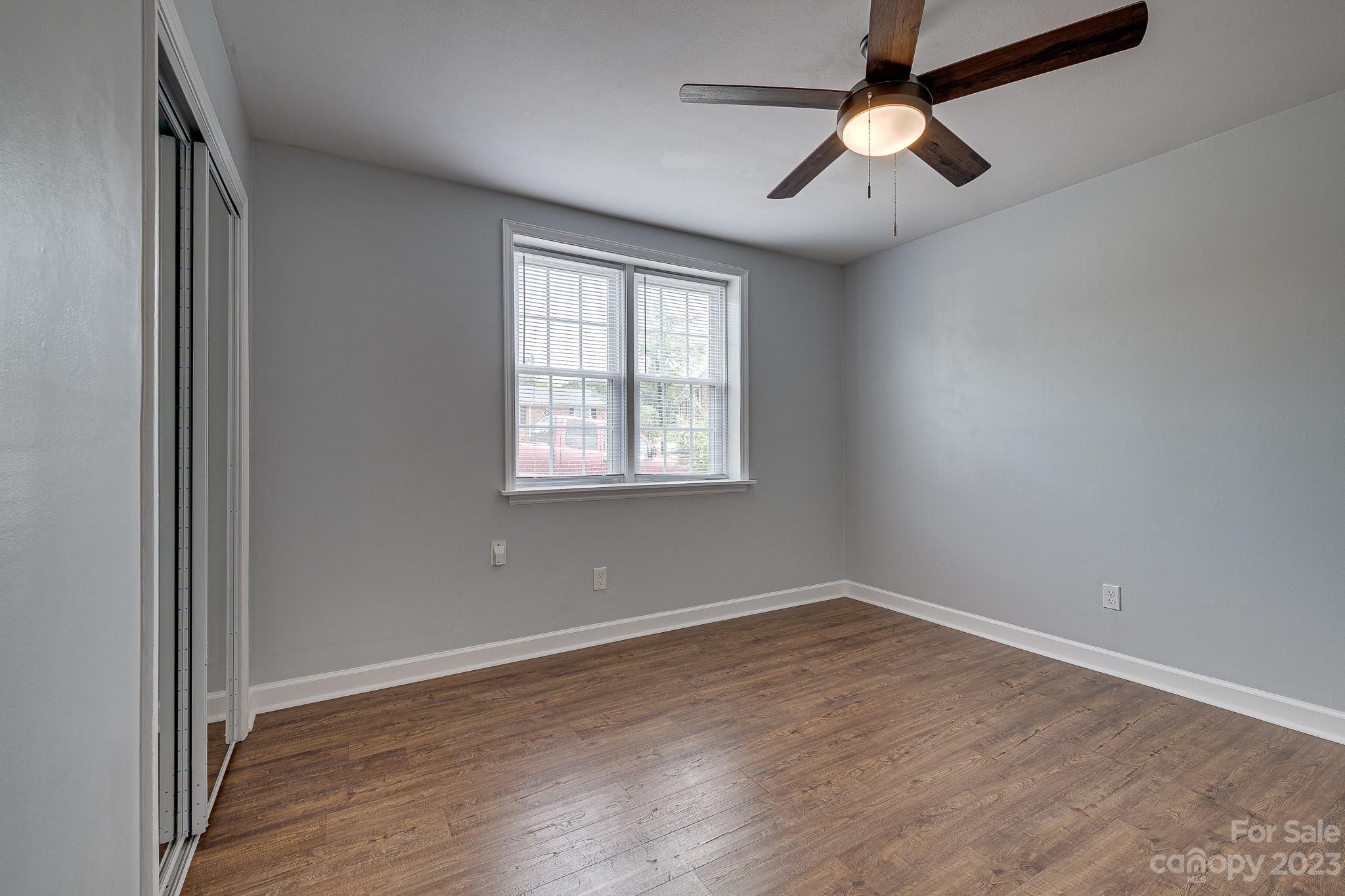 910 McAlway Road, Unit B Charlotte, NC 28211 - Photo 19 of 37 an empty room with wooden floor ceiling fan and windows