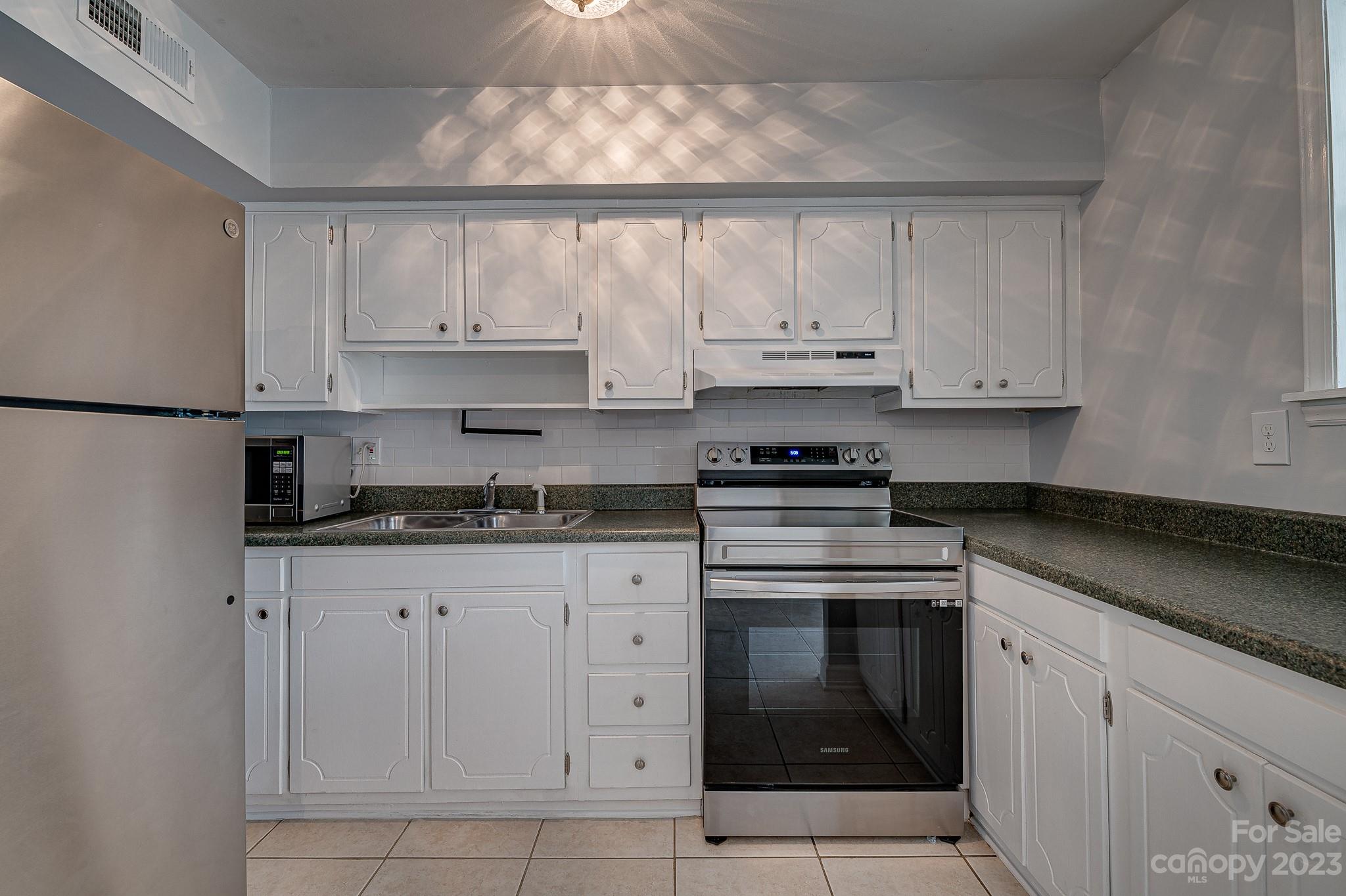 910 McAlway Road, Unit B Charlotte, NC 28211 - Photo 2 of 37 a kitchen with granite countertop white cabinets and stainless steel appliances