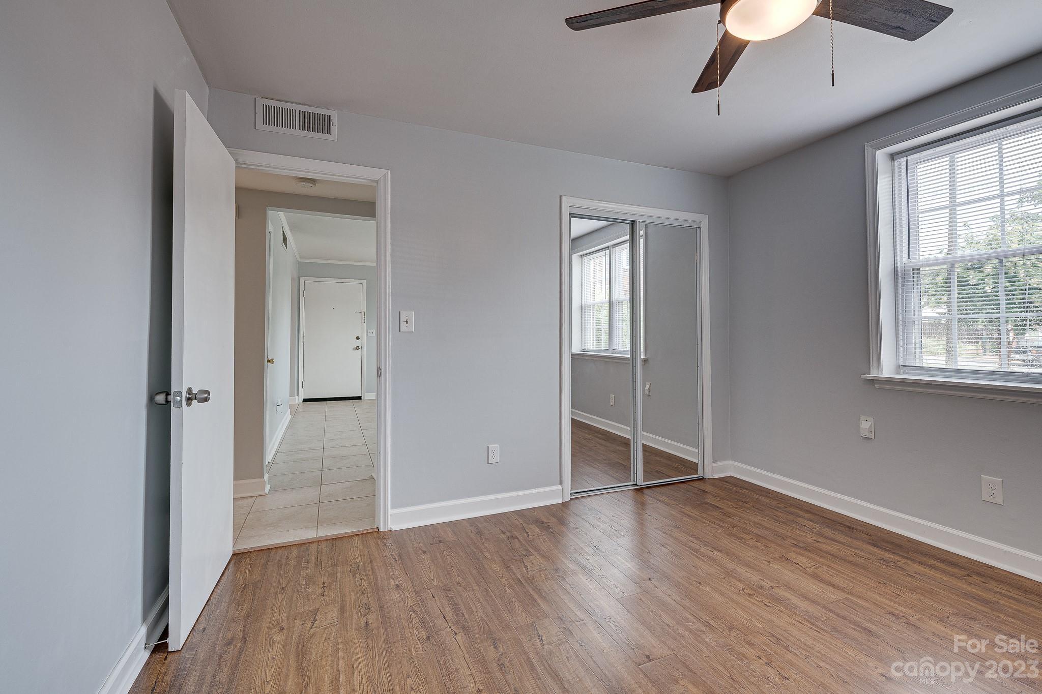 910 McAlway Road, Unit B Charlotte, NC 28211 - Photo 21 of 37 an empty room with wooden floor chandelier and windows