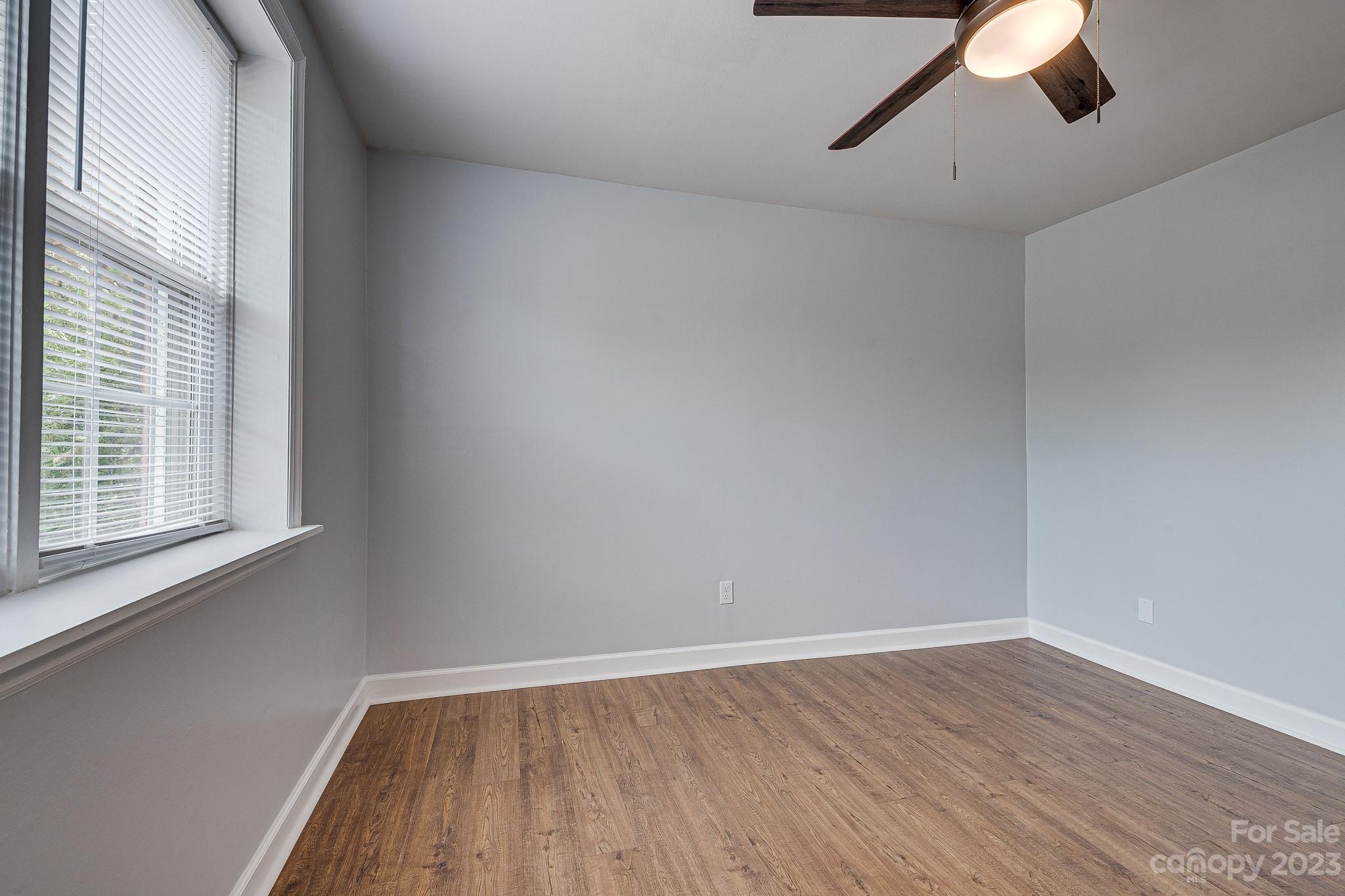 910 McAlway Road, Unit B Charlotte, NC 28211 - Photo 24 of 37 a view of an empty room with wooden floor and a window