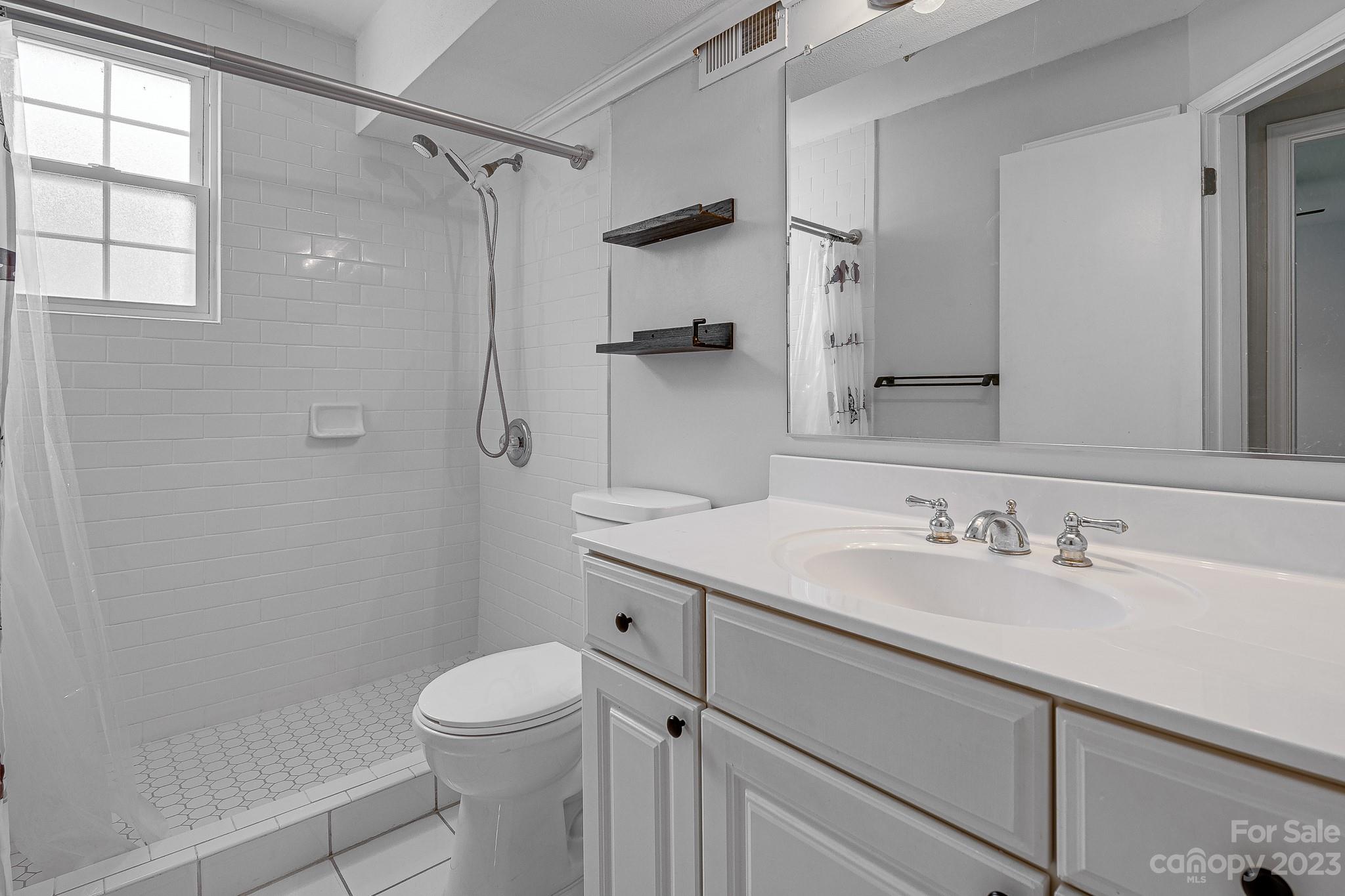 910 McAlway Road, Unit B Charlotte, NC 28211 - Photo 32 of 37 a bathroom with a sink a toilet and shower