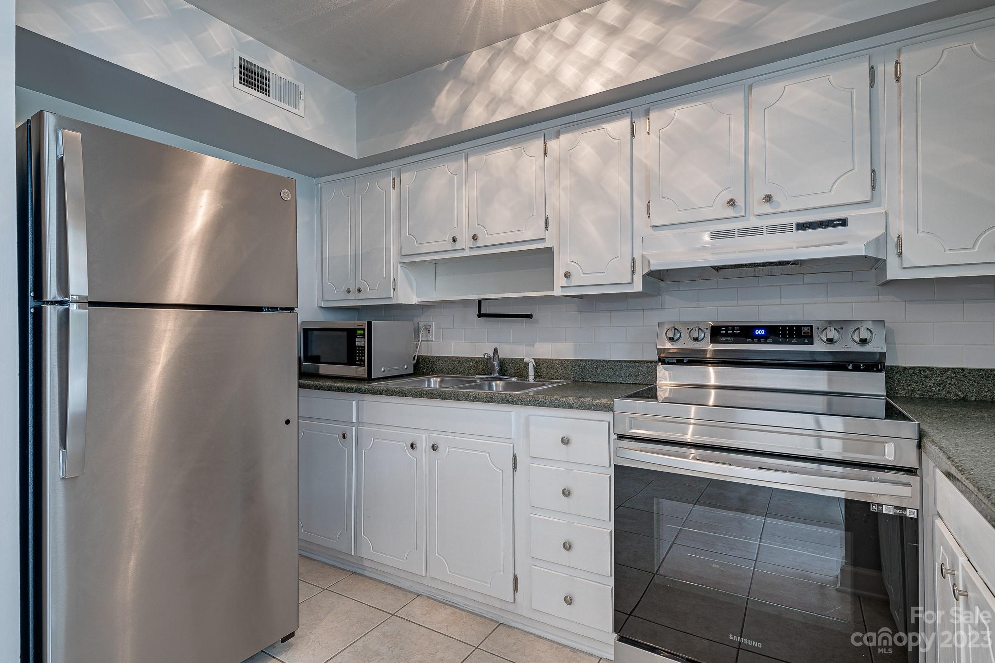 910 McAlway Road, Unit B Charlotte, NC 28211 - Photo 4 of 37 a kitchen with stainless steel appliances granite countertop a refrigerator sink and cabinets