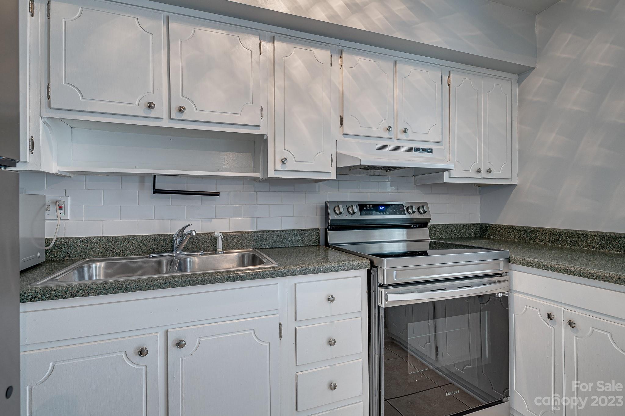 910 McAlway Road, Unit B Charlotte, NC 28211 - Photo 5 of 37 a kitchen with granite countertop white cabinets and a stove