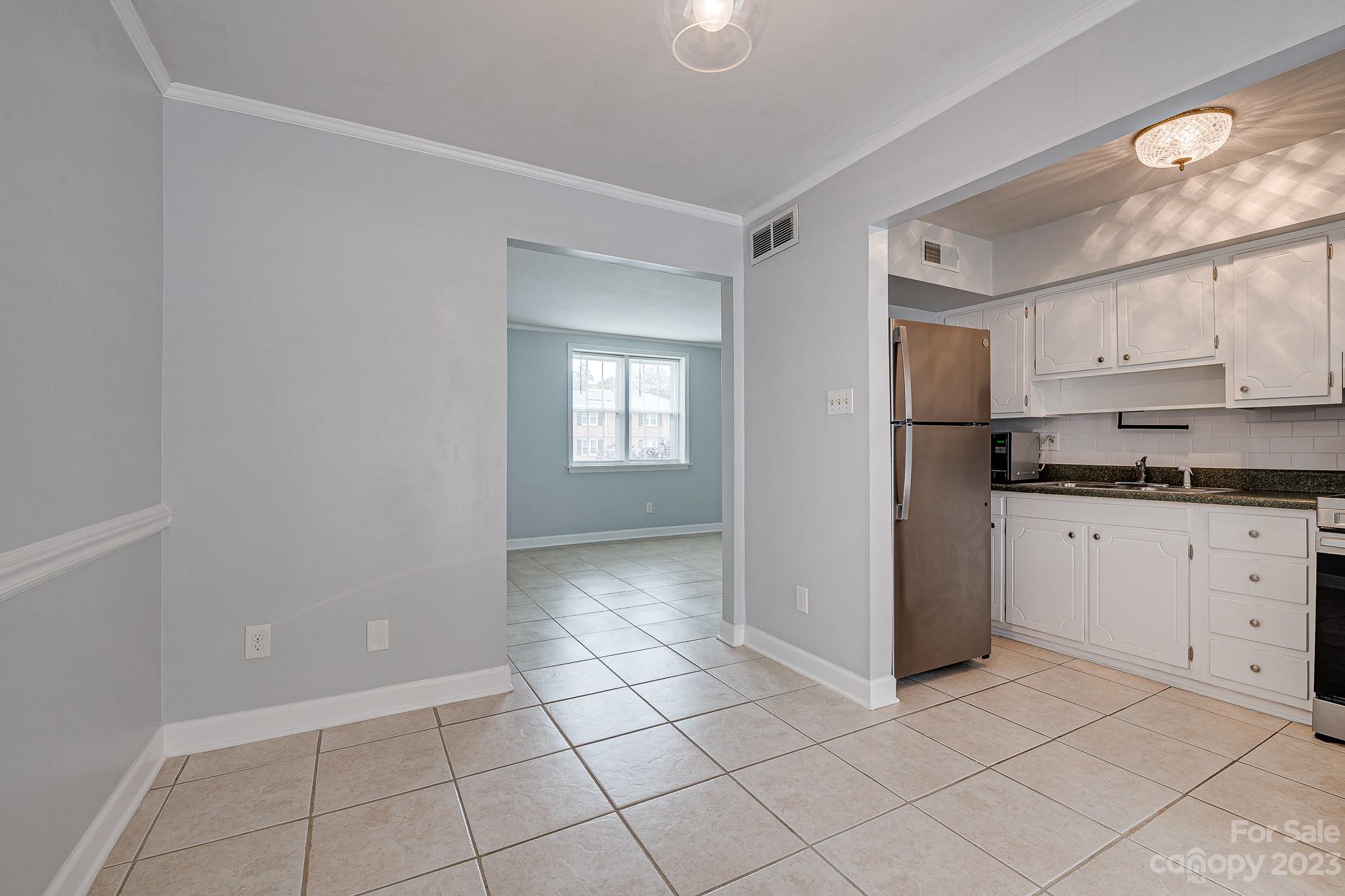 910 McAlway Road, Unit B Charlotte, NC 28211 - Photo 8 of 37 a kitchen with white cabinets and a refrigerator