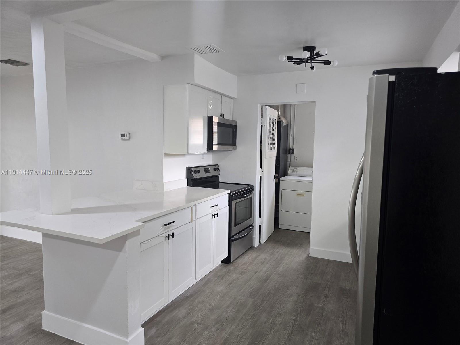 3801 Northwest 8th Court Lauderhill, FL 33311 - Photo 3 of 7 a kitchen with white cabinets and stainless steel appliances
