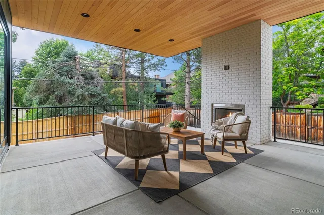 a backyard of a house with wooden floor barbeque oven and outdoor seating