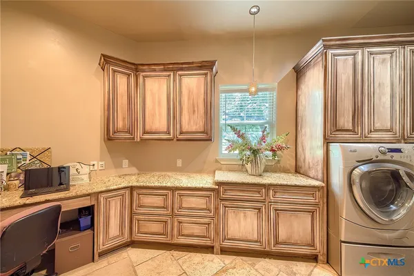 a kitchen with granite countertop a sink a stove cabinets and stainless steel appliances