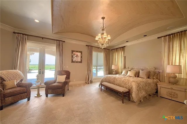a spacious bedroom with a bed a couch and potted plant in front of window