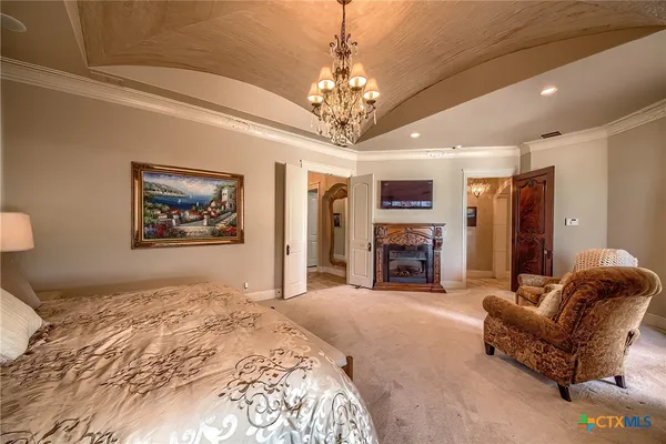a spacious bedroom with a bed and ceiling fireplace