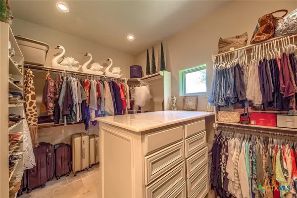 a view of walk in closet with clothes and shoes