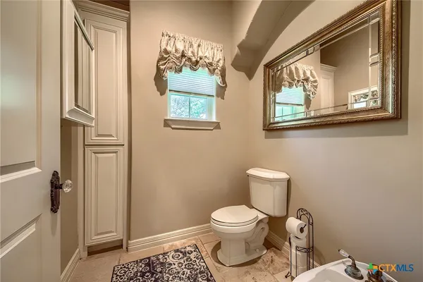 a white toilet sitting next to a bathroom sink