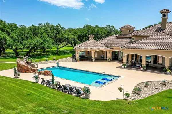 a swimming pool with outdoor seating and yard