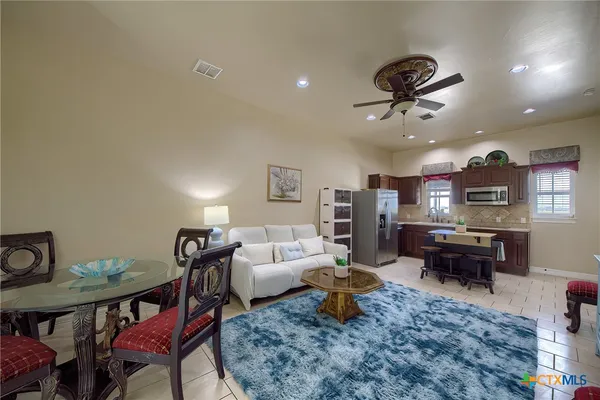 a living room with furniture kitchen view and a dining table