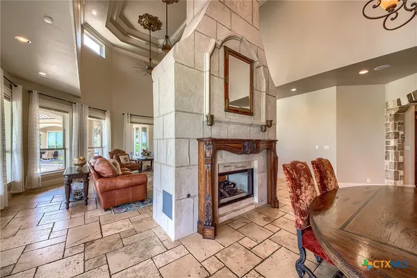 a living room with furniture a fireplace and a floor to ceiling window