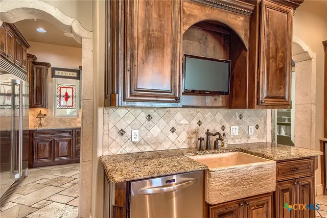 a kitchen with granite countertop a sink and a stove