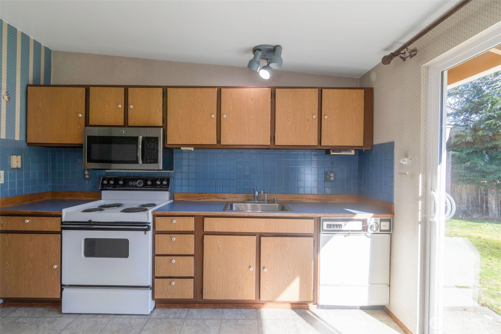 308 225th Street Southwest Bothell, WA 98021 - Photo 5 of 15 a kitchen with a stove a sink and a microwave