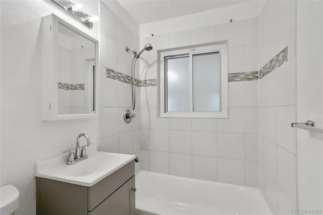 a bathroom with a bathtub shower sink vanity and toilet