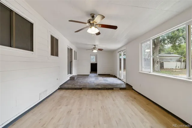 a view of a livingroom with a ceiling fan and wooden floor