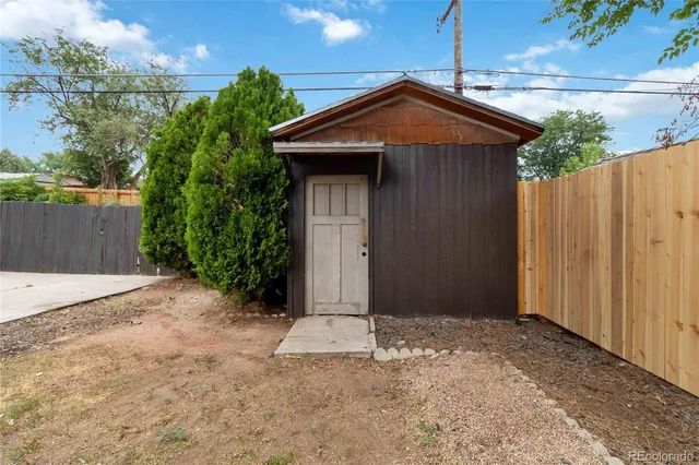 a view of a backyard with a garden and tree