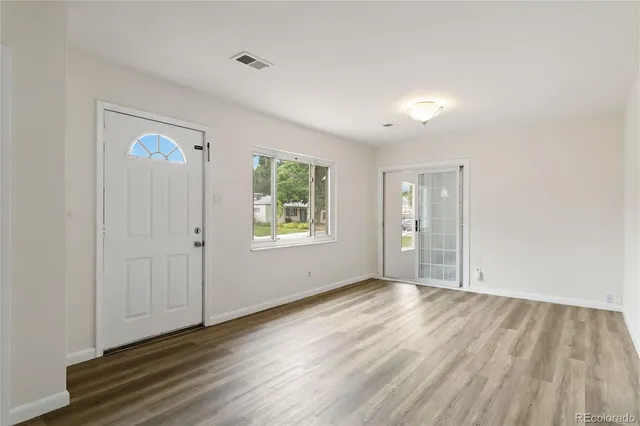 an empty room with windows and closet