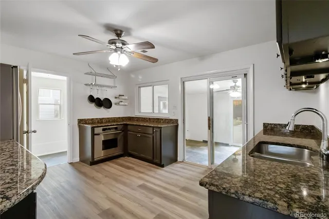 a kitchen with kitchen island granite countertop a stove and a sink with granite countertops