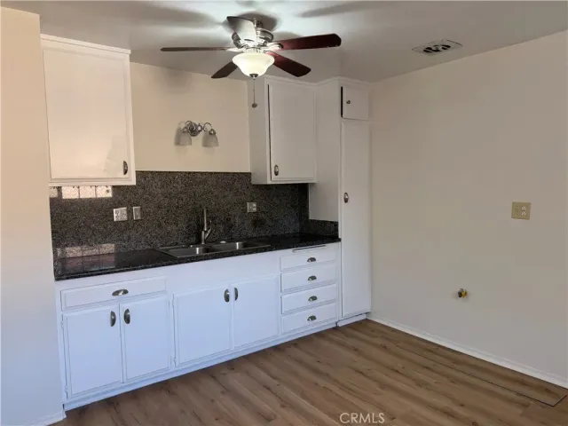 a kitchen with granite countertop white cabinets and stainless steel appliances