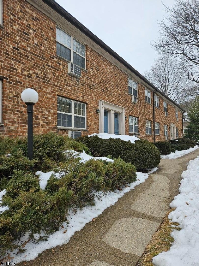 a front view of a house with yard and parking