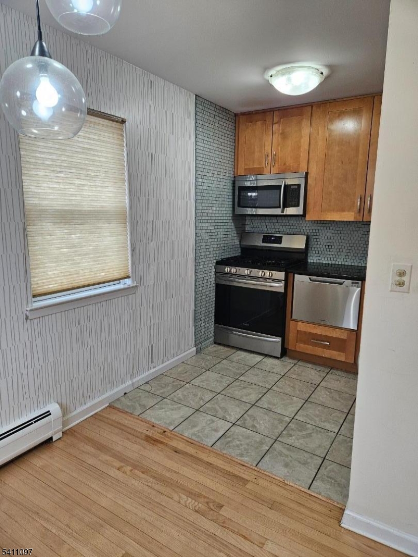 19 Savage Road, Unit 32D8 Denville, NJ 07834 - Photo 10 of 19 a kitchen with granite countertop a stove a sink and a microwave