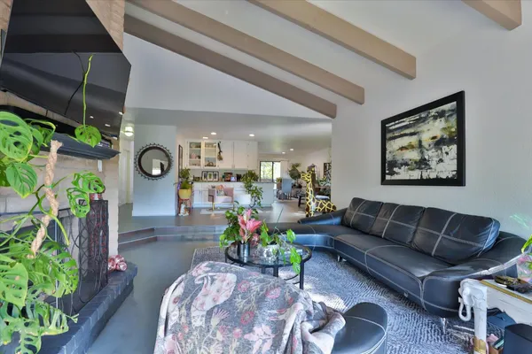 a bedroom with a large bed chandelier and a window