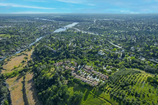 an aerial view of residential house with green space and trees all around
