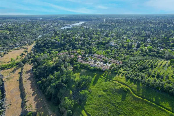 an aerial view of residential houses with outdoor space and trees