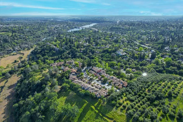 an aerial view of residential houses with outdoor space and trees