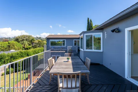 a balcony with wooden floor table and chairs