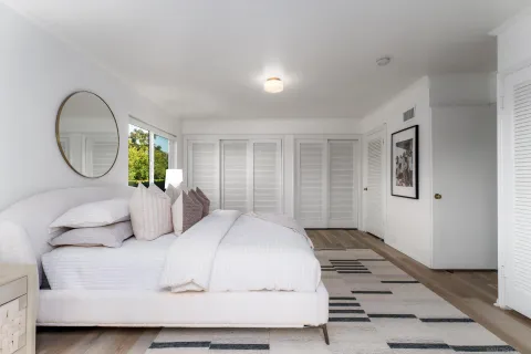 a bedroom with a large bed and a mirror
