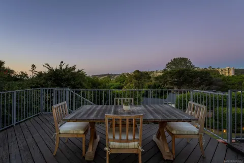 a view of a roof deck with table and chairs a barbeque with wooden floor and fence