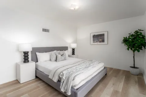 a bedroom with bed and a potted plant