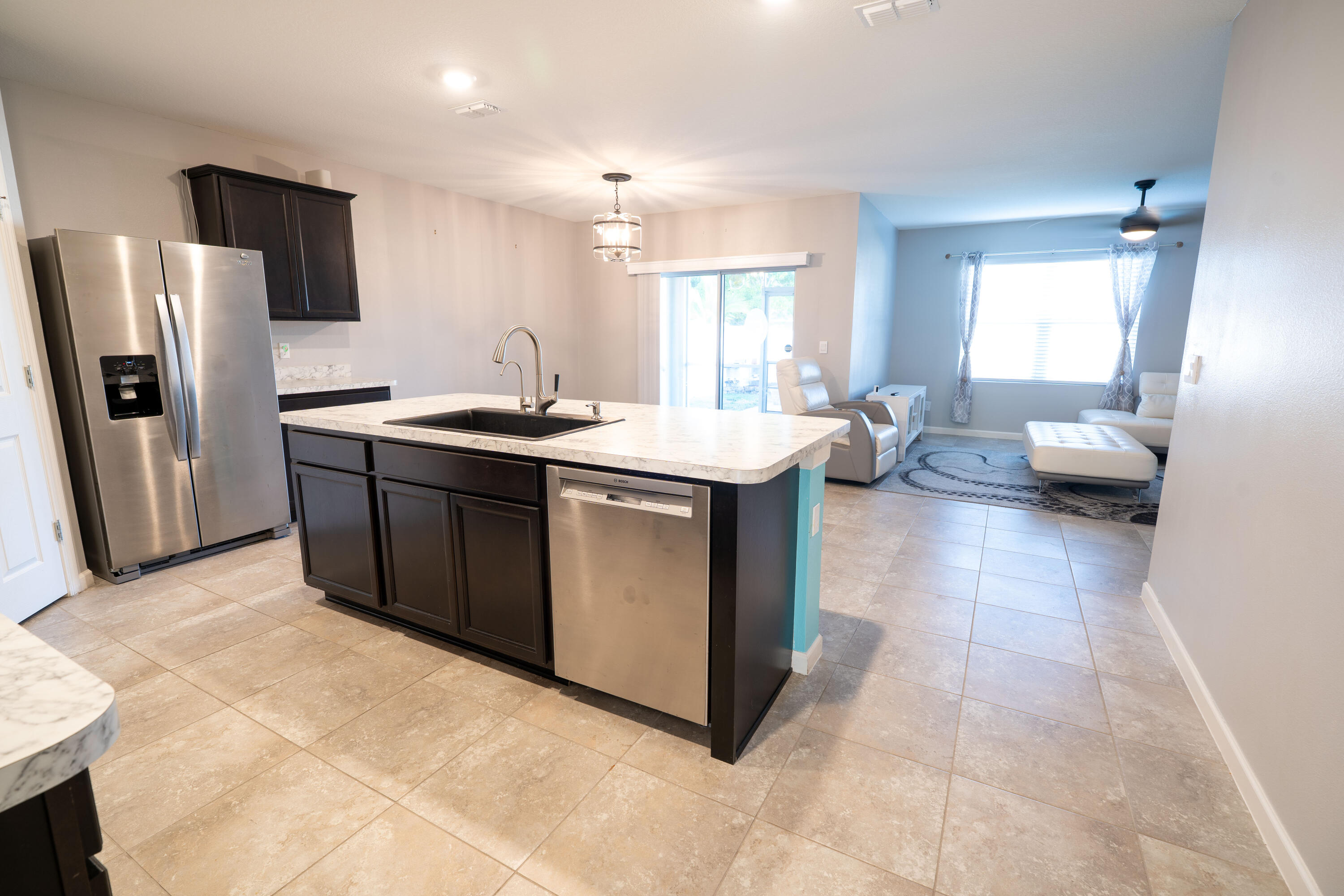 1401 Southeast Portillo Road Port St. Lucie, FL 34952 - Photo 12 of 37 a kitchen with stainless steel appliances granite countertop a sink and dishwasher a refrigerator with wooden floor
