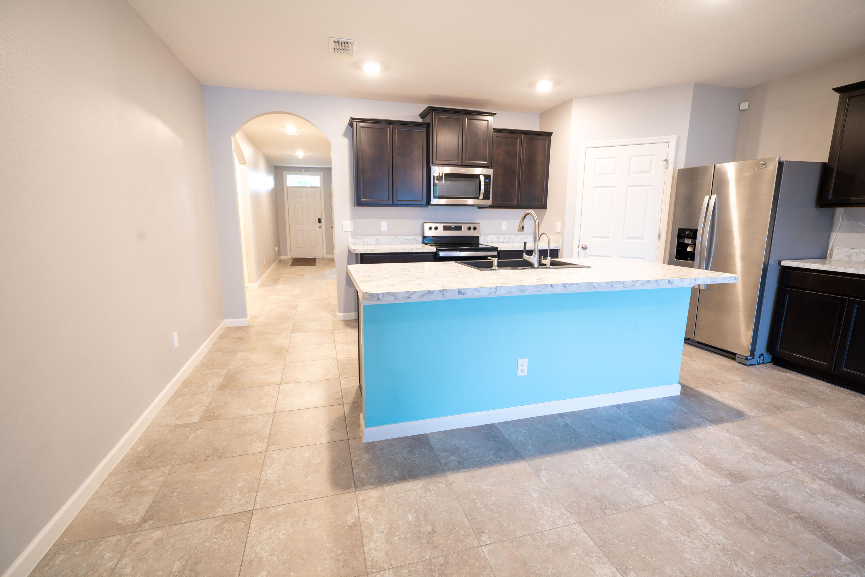 1401 Southeast Portillo Road Port St. Lucie, FL 34952 - Photo 14 of 37 a kitchen with stainless steel appliances granite countertop a sink a stove a refrigerator a microwave and cabinets