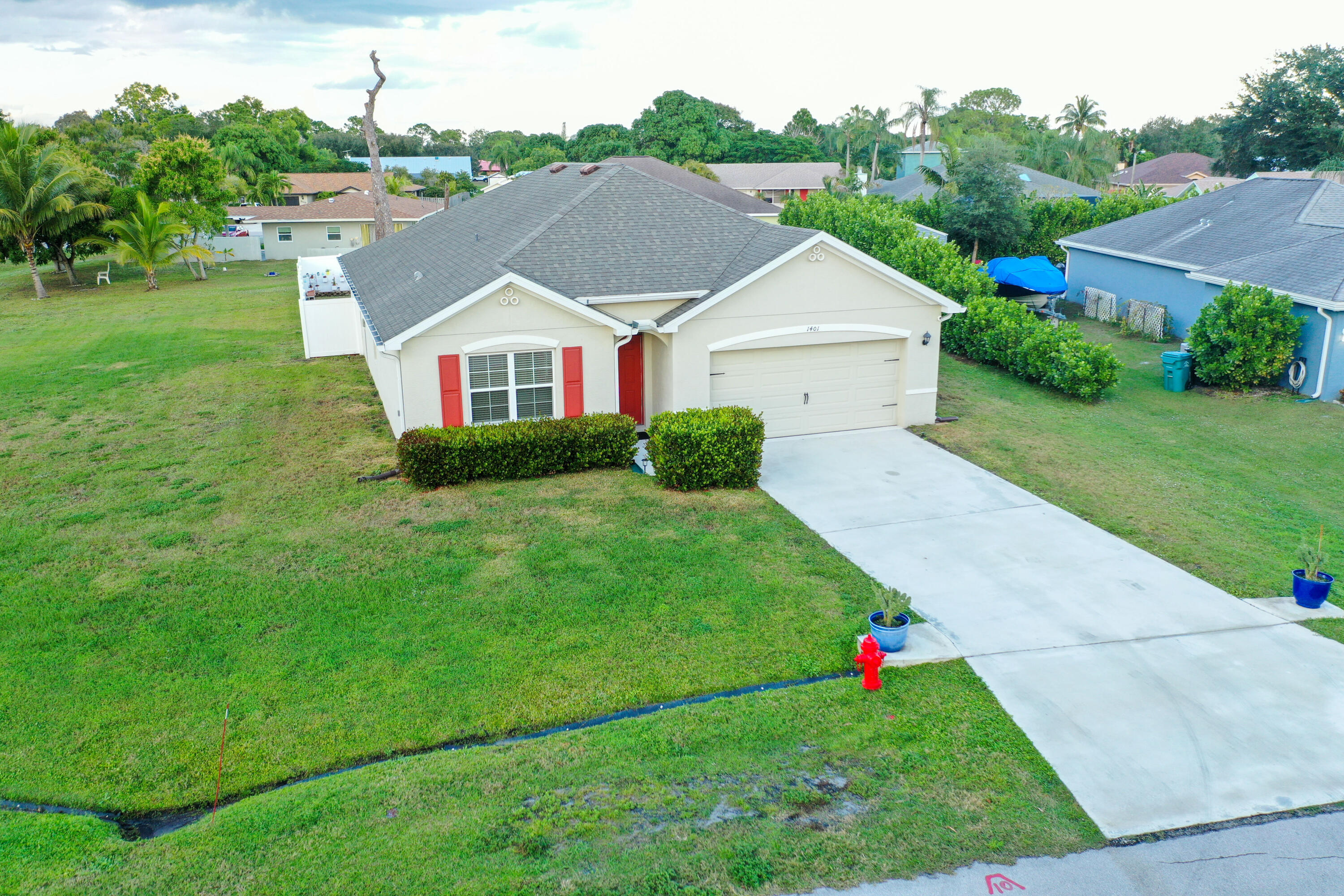 1401 Southeast Portillo Road Port St. Lucie, FL 34952 - Photo 31 of 37 a aerial view of a house next to a big yard and large trees