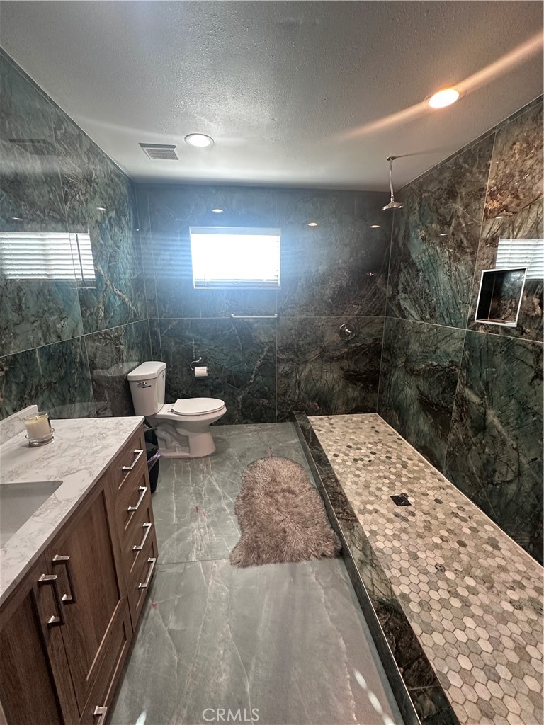 14426 Tumbleweed Road Phelan, CA 92371 - Photo 19 of 38 a bath room with a sink a toilet and a shower