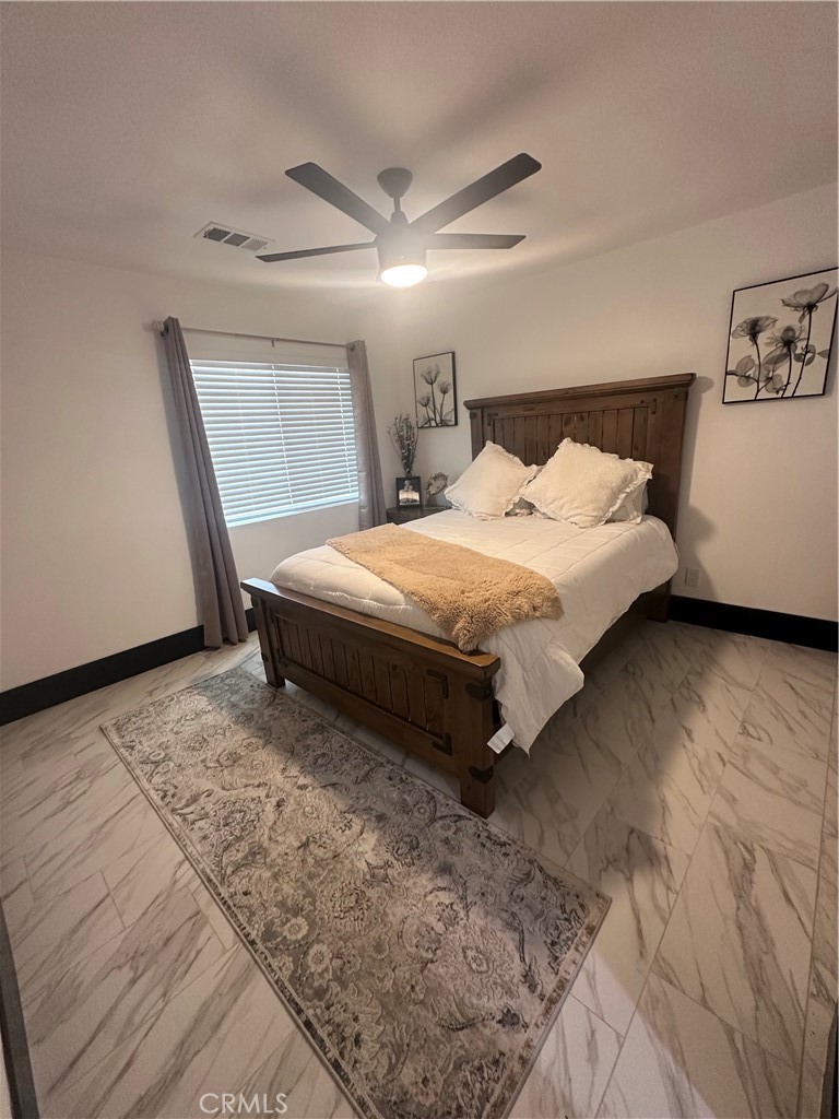14426 Tumbleweed Road Phelan, CA 92371 - Photo 22 of 38 a spacious bedroom with a bed and a window