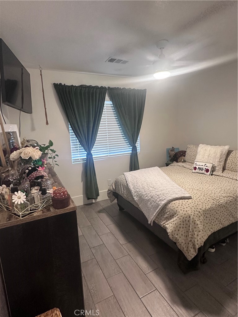 14426 Tumbleweed Road Phelan, CA 92371 - Photo 25 of 38 a bedroom with a bed potted plant on the dresser and a table