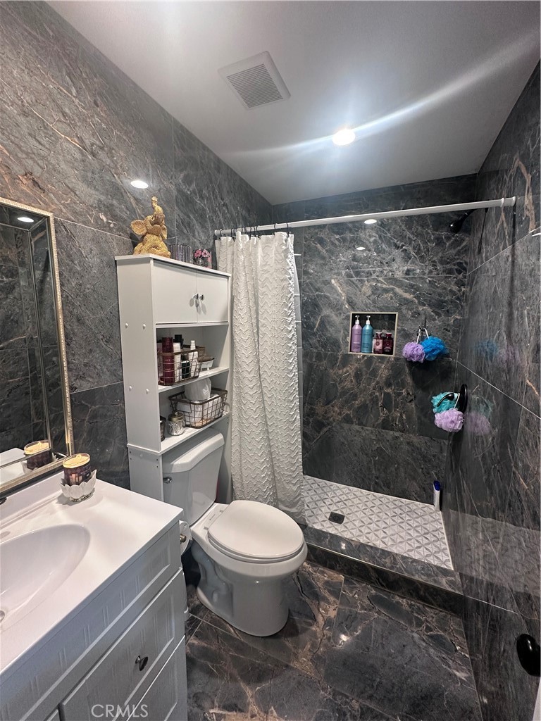 14426 Tumbleweed Road Phelan, CA 92371 - Photo 27 of 38 a bathroom with a sink a toilet and shower