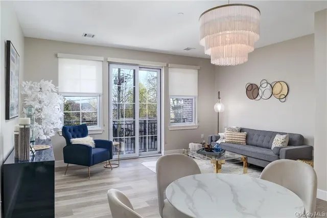 a living room with furniture chandelier and a large window