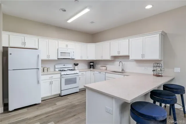 a kitchen with a white stove top oven and white cabinets