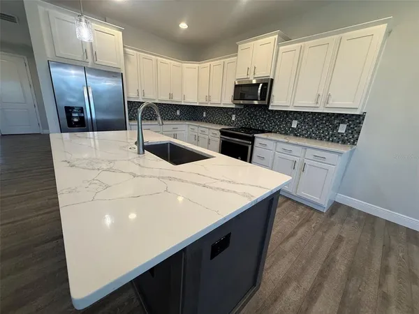 a kitchen with stainless steel appliances a refrigerator sink and stove